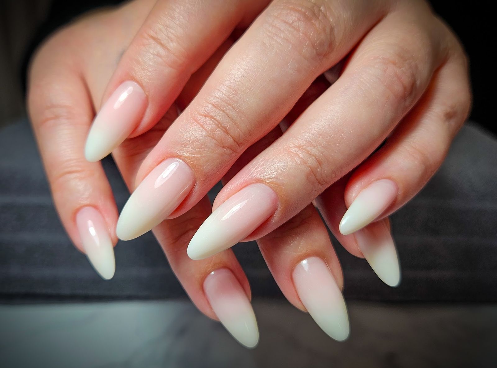 Lange amandelnagels met een zachte ombre van wit naar nude