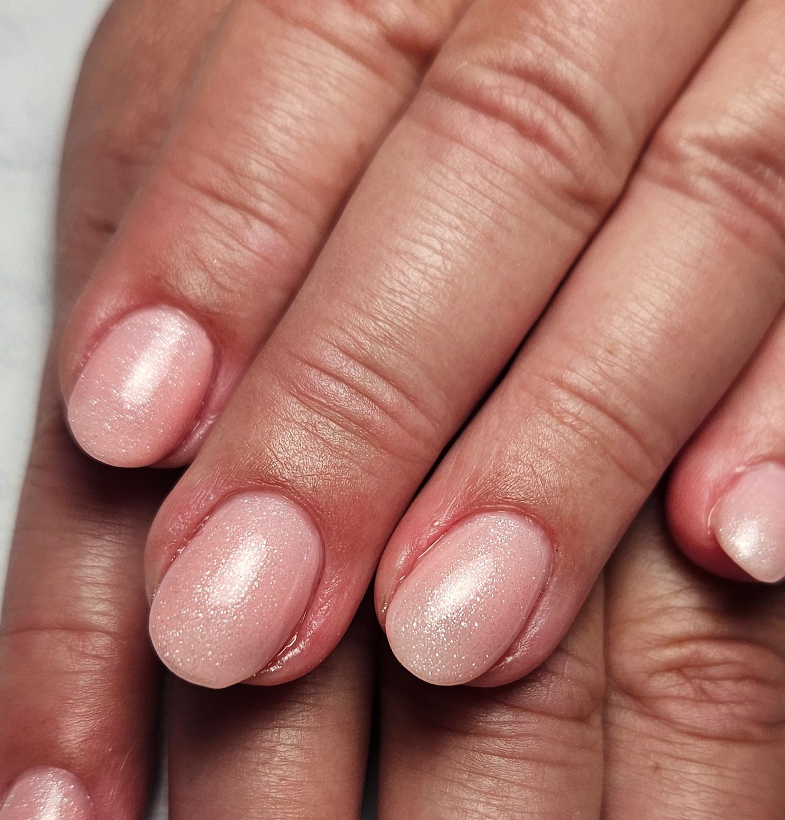 Korte natuurlijke nagels met een roze parelmoerglans