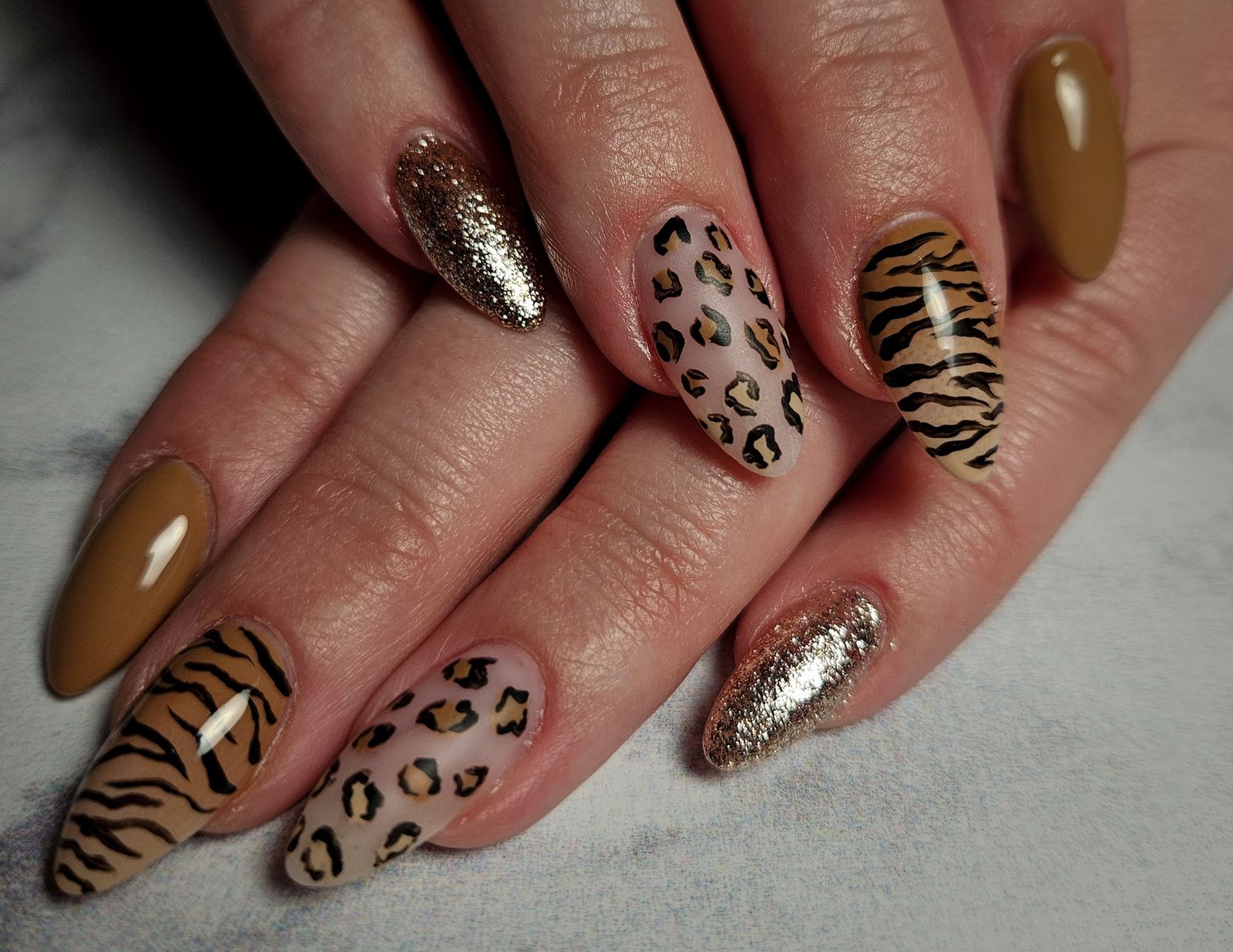 Nail art met luipaard- en tijgerprint, goudglitter en karamelkleur