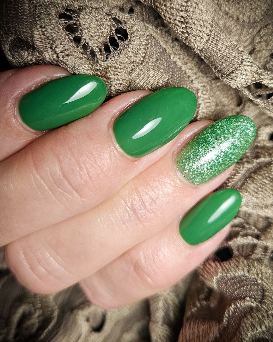 Groene gelnagels met een glitternagel op gehaakte stof