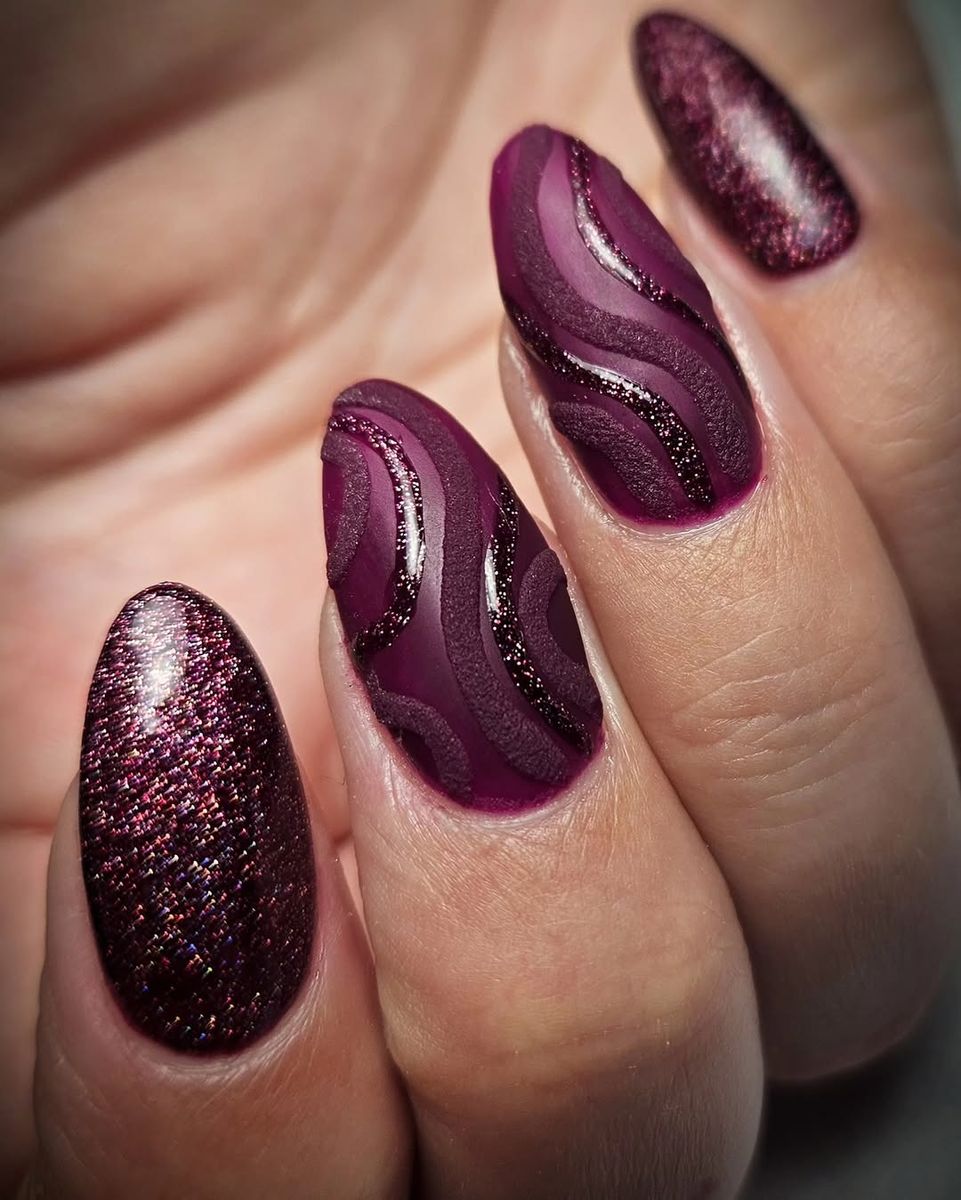 Bordeauxrode nagels met glitter en een mat golfdesign
